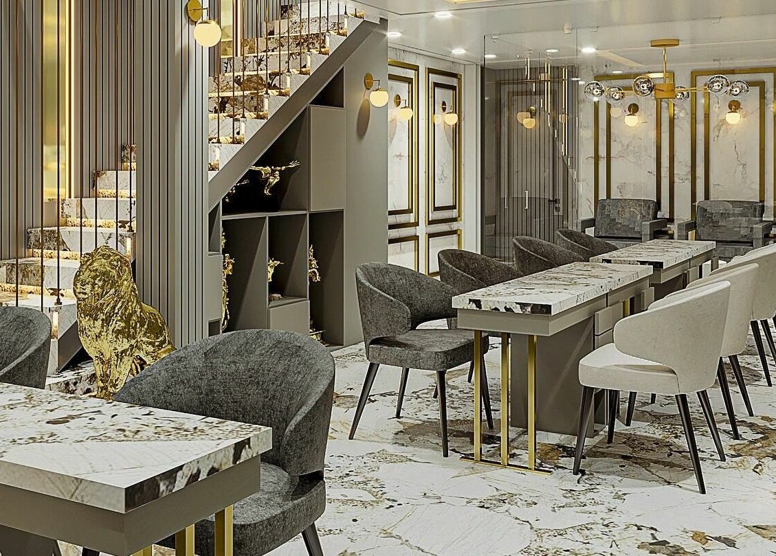 Interior de Eztravaganzza Nailroom Plus en Chihuahua, Chihuahua, MX con diseño en mármol y asientos elegantes.