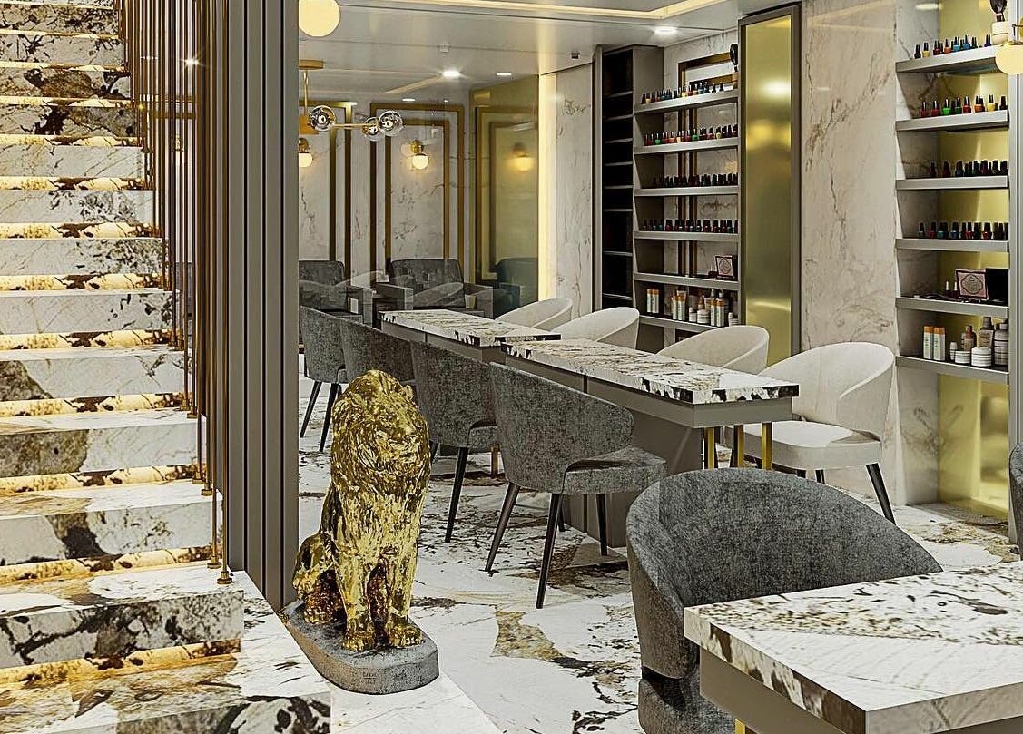 Interior elegante de Eztravaganzza Nailroom Plus en Chihuahua, Chihuahua, MX con decoración de mármol y sillas modernas.