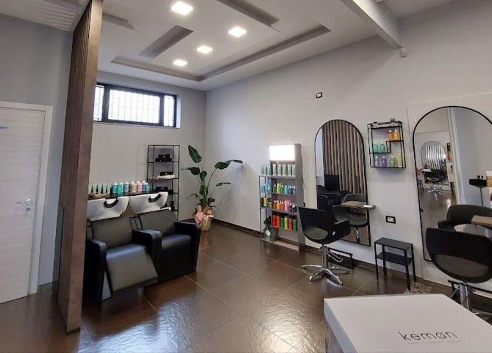 Interni eleganti del salone Valentina Migliaro a San Valentino Torio, Campania, IT, con sedie nere e specchi.