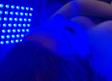 Facial therapy under blue light at Beauty and the Belle in Ash Vale, England, GB, enhancing skin wellness.