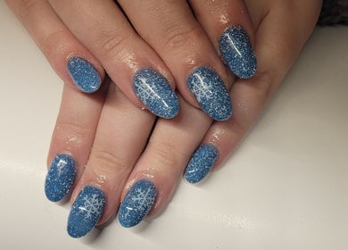Blue glitter nails with snowflakes at Glam On The Lash, Trimley Saint Mary, England, GB.