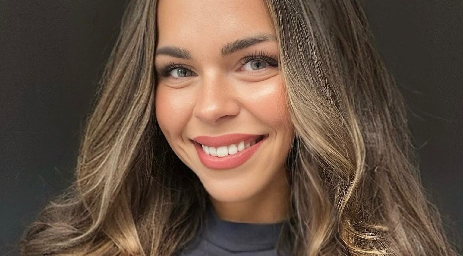 A woman with a radiant smile and styled hair, showcasing services at Belle Beauty and Academy, Montréal, Québec, CA.