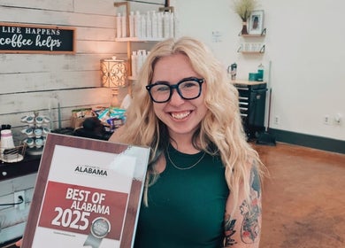 Smiling stylist with award at Luna Jade Salon Independant Stylists in Athens, Alabama, US.