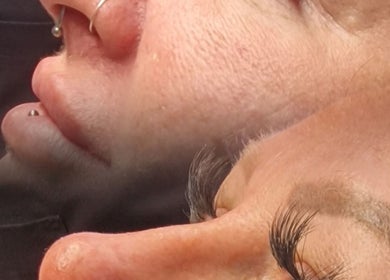 Close-up of facial piercings and eyelashes at Amethyst Aesthetics Exmouth, Exmouth, England, GB.