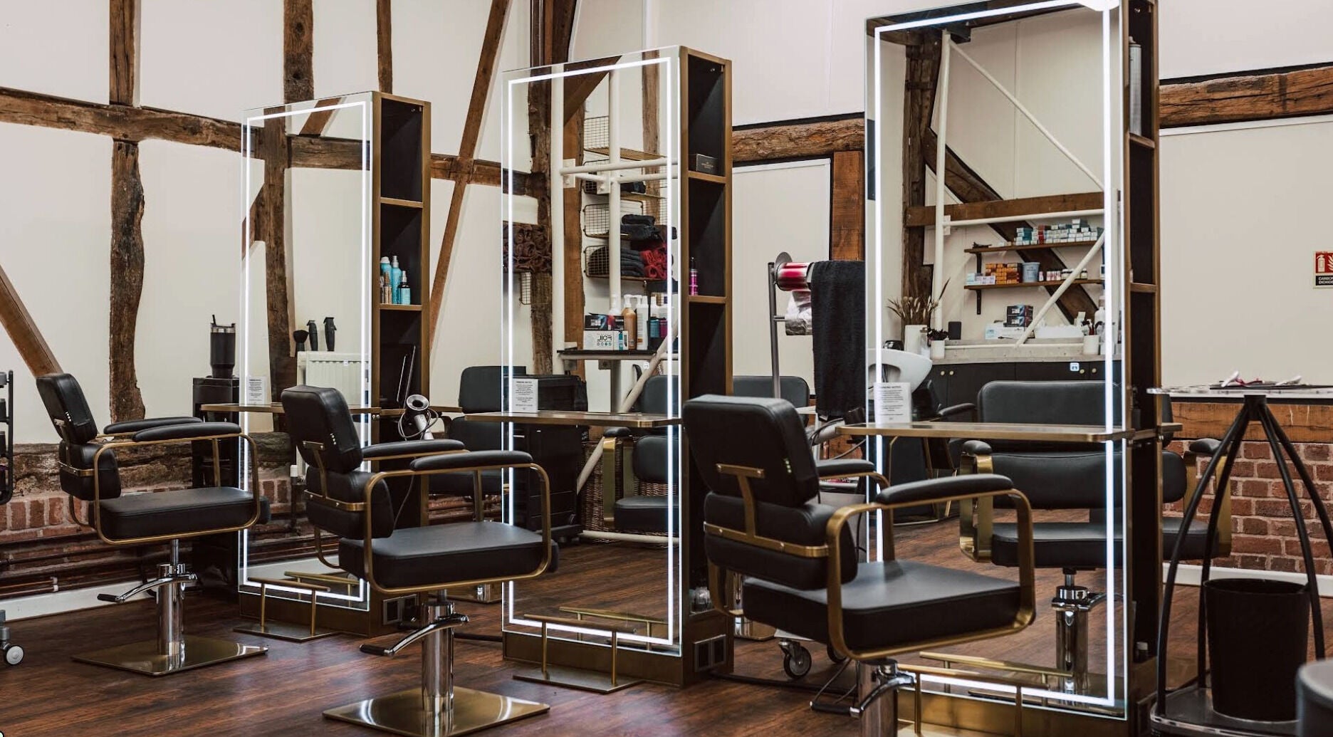 Modern salon interior at Strutt It Hair and Beauty, Redditch, England, GB. Stylish chairs and illuminated mirrors.