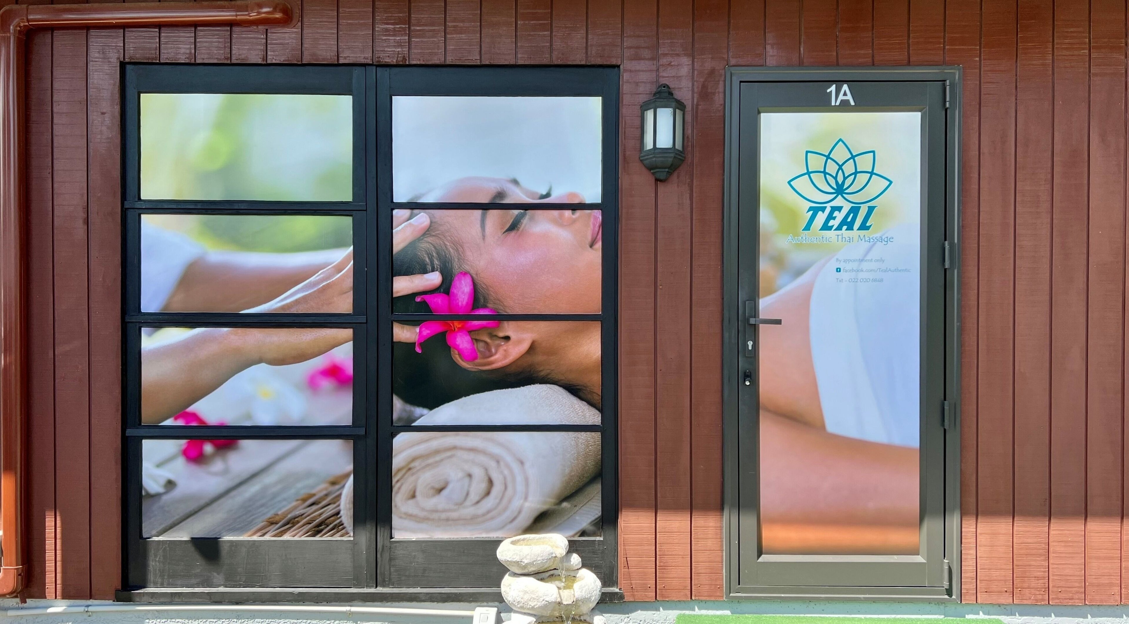 Entrance of Teal Authentic Thai Massage in Gisborne, NZ, showcasing serene spa imagery and signage.