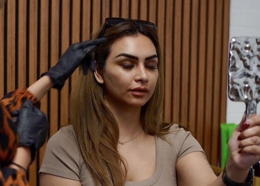 Client admires results of beauty treatment at Anisa Aesthetics, Peterborough, England, GB, enhancing natural beauty.