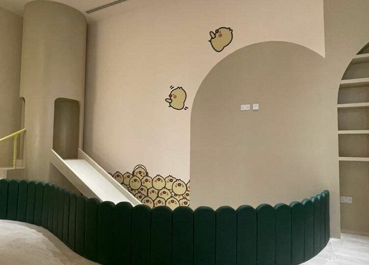 Children's play area at Little Scissors Kids Salon, Abu Dhabi, Abu Dhabi, AE with colorful slide and decor.
