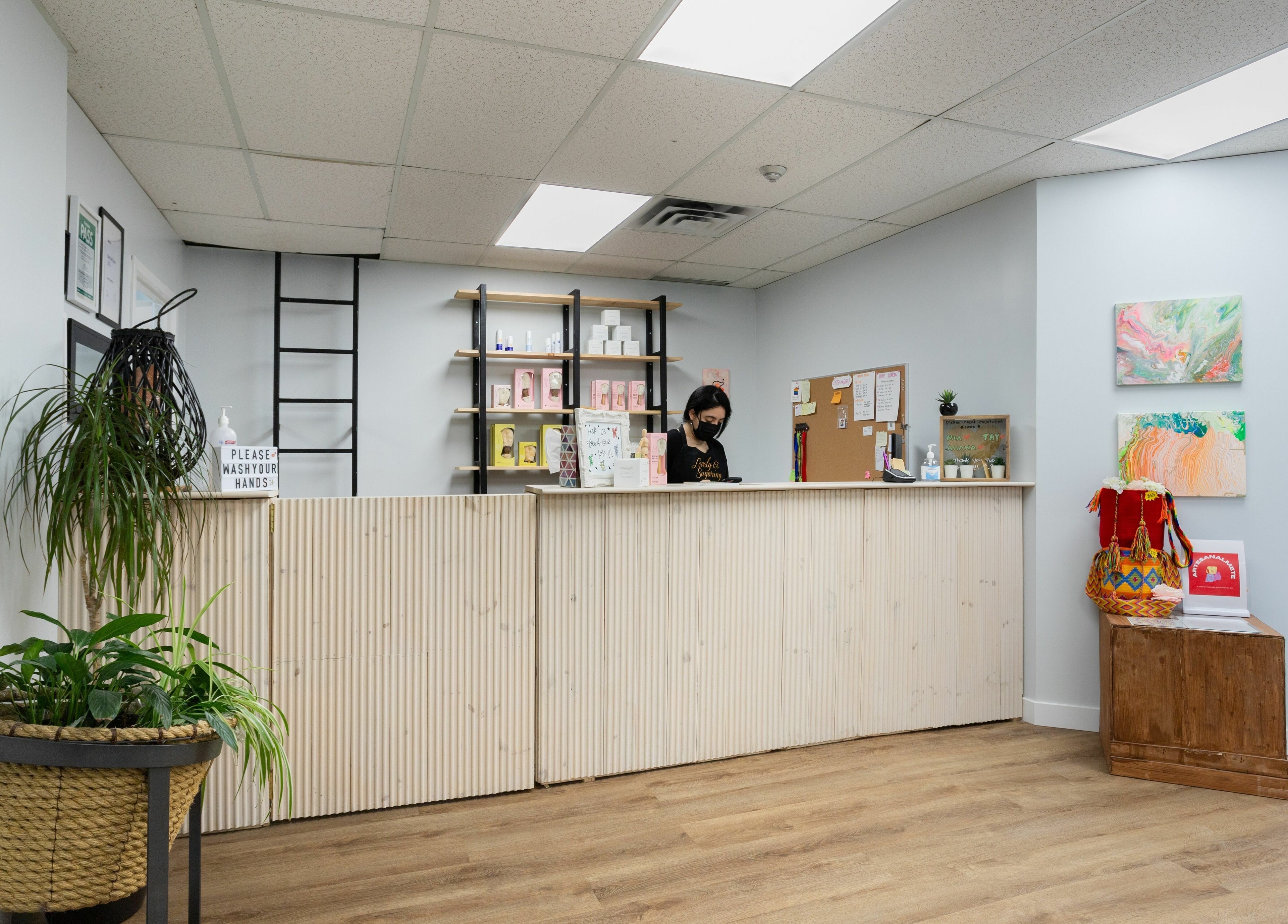 Lovely Sugaring's welcoming reception area in Toronto, Ontario, CA features modern decor and vibrant art pieces.