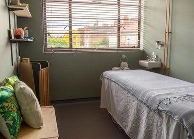 Relaxing treatment room at The Healing Spa, Portsmouth, England, GB with a massage bed and cozy decor.
