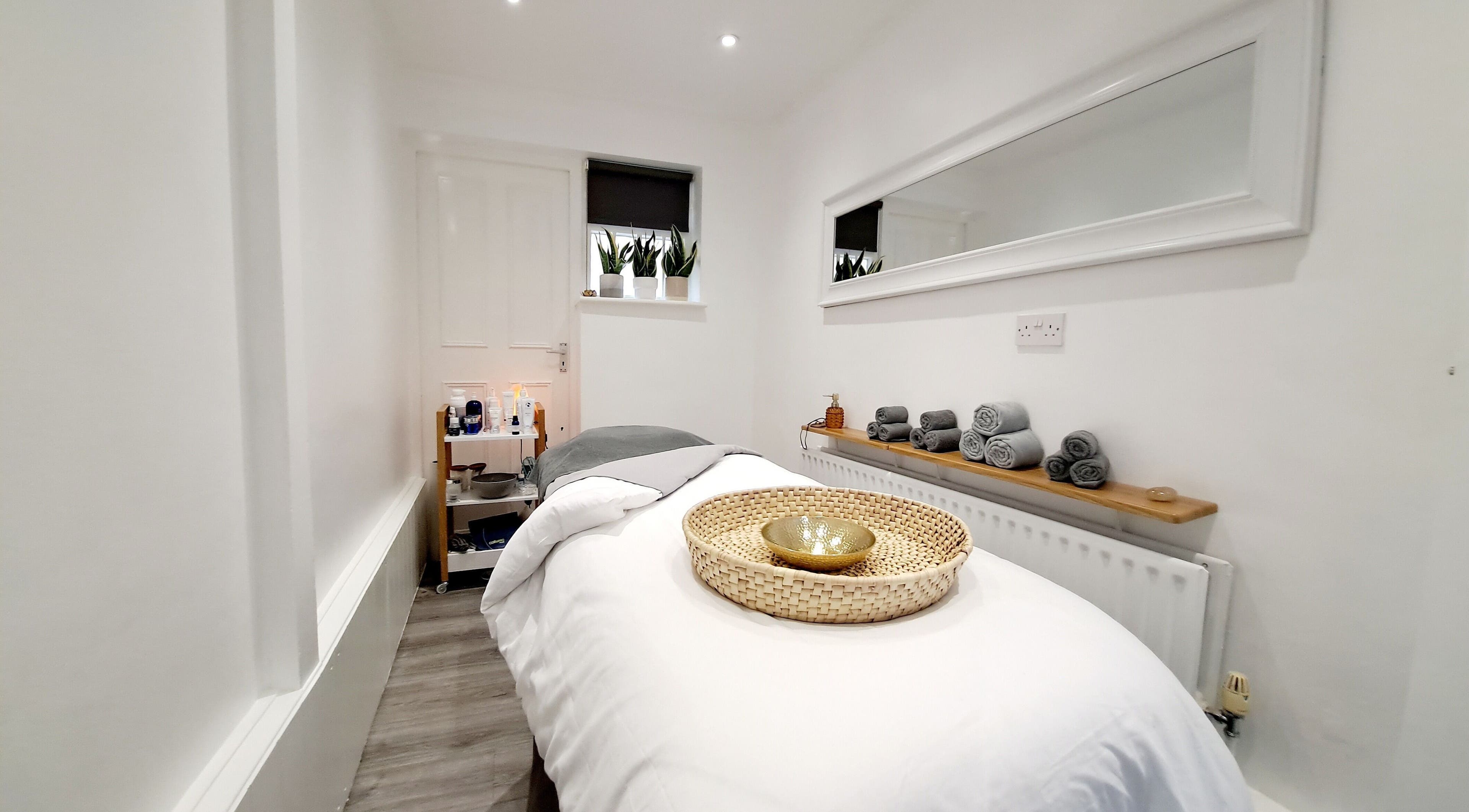 Calming treatment room at My Face Spa, London, England, GB with a cozy massage bed and soft lighting.