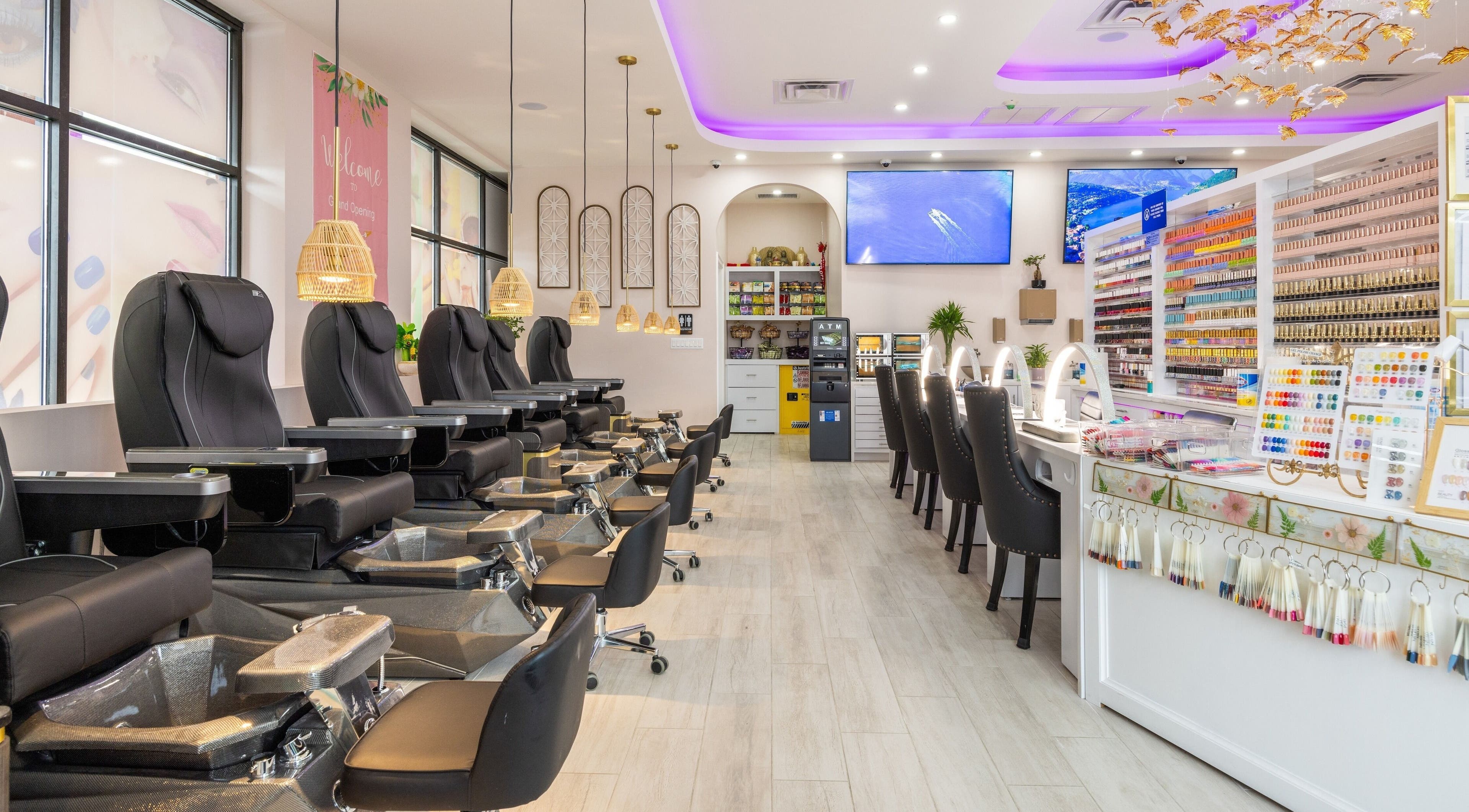 Elegant salon interior of The Nail Palace in Lowell, Massachusetts, US with plush seating and vibrant nail polishes.