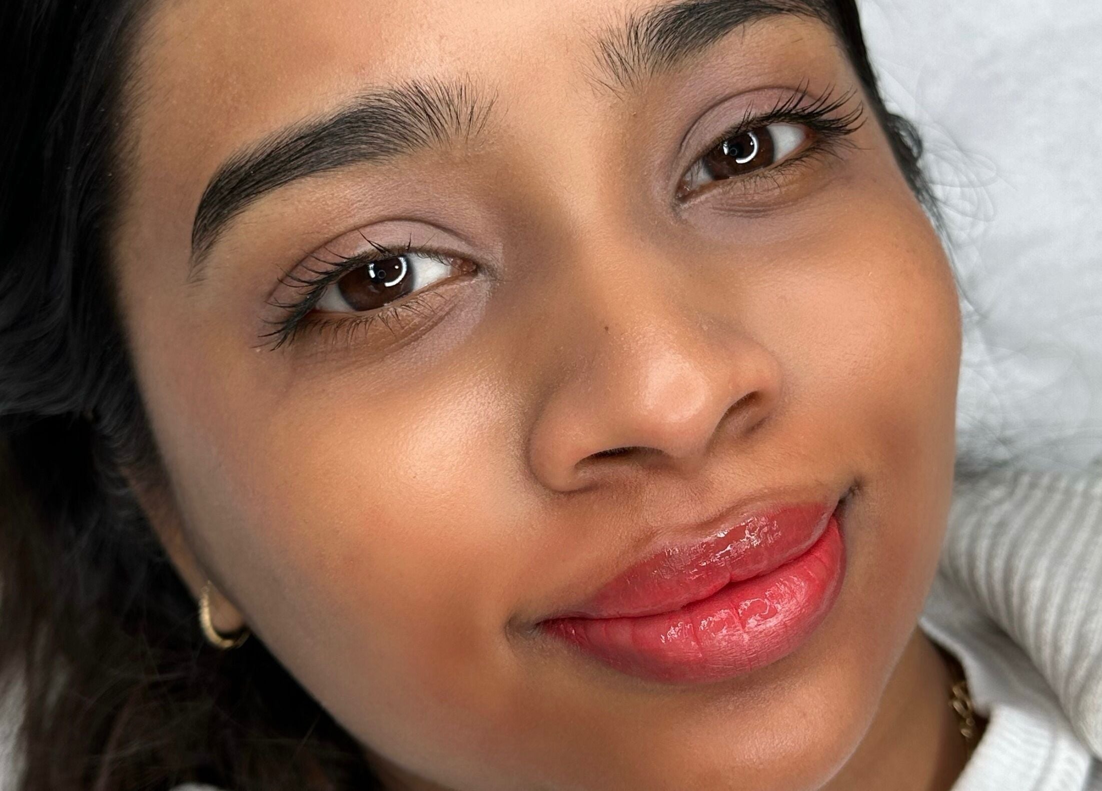 Close-up of a smiling client with glowing skin at AURA THE CLINIC, Newcastle upon Tyne, England, GB.