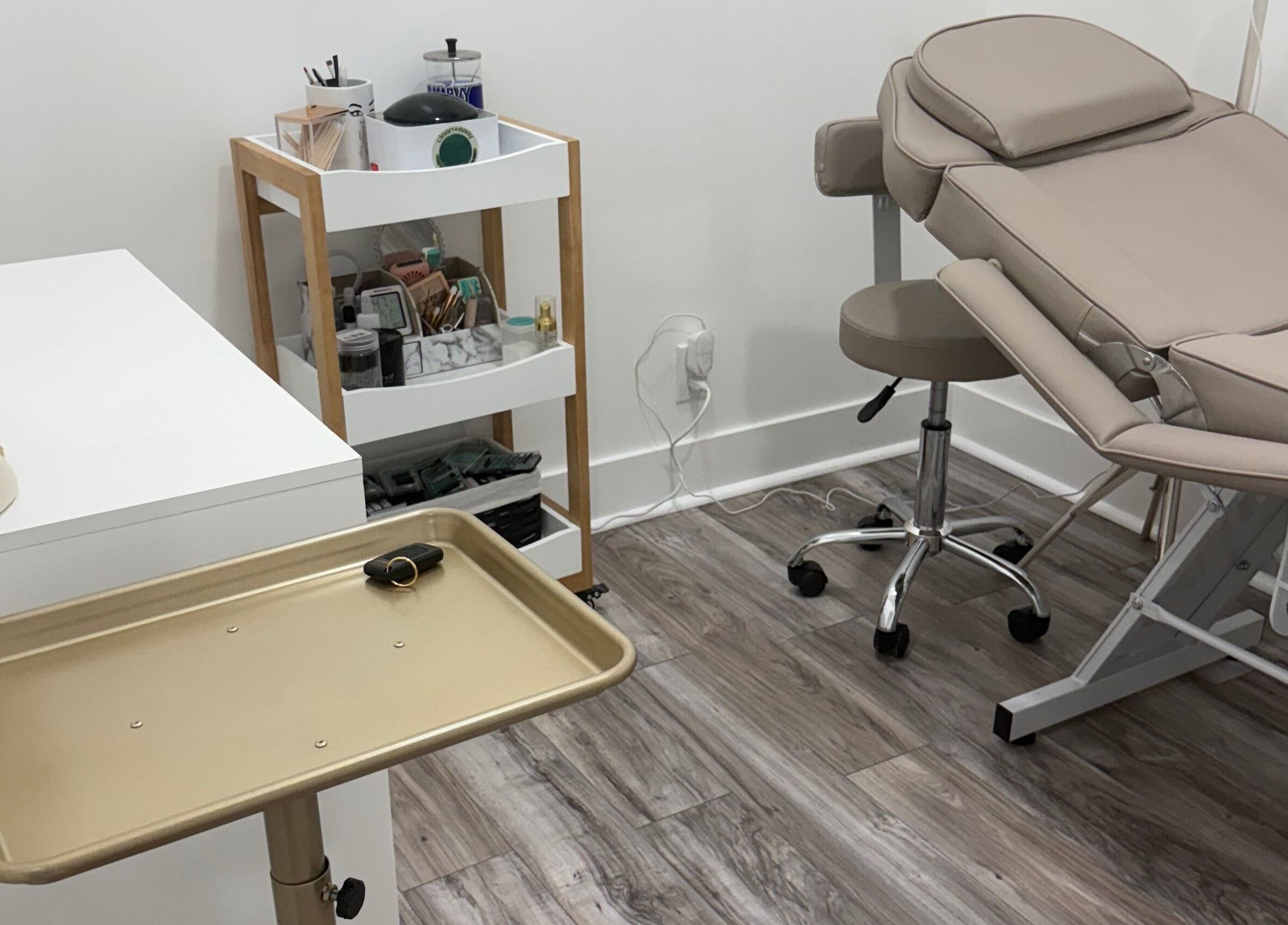 Treatment room at N’Luxe Beauty Lounge in Chicago, Illinois, US with beige chair and modern decor.