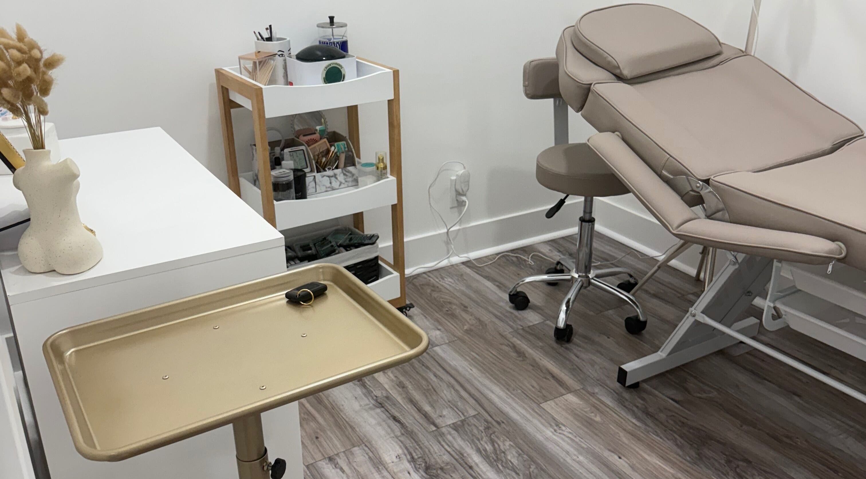 Treatment room at N’Luxe Beauty Lounge in Chicago, Illinois, US with beige chair and modern decor.