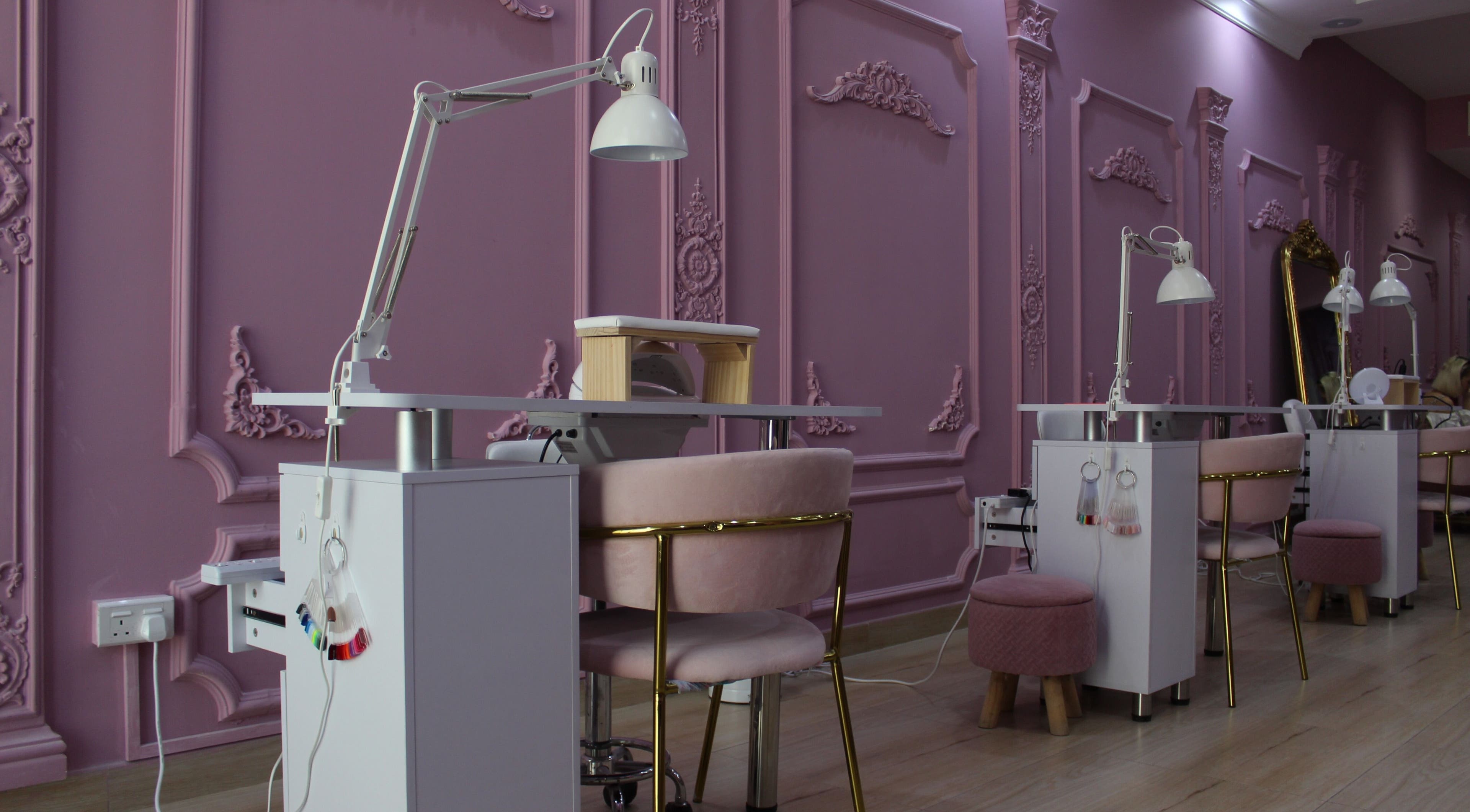 Interior of Foxy Lane Russian Nail Salon, Dubai, with elegant pink decor and manicure stations.