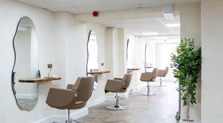 Modern salon interior at Jennifer Holmes Hair and Beauty Ltd, Masham, England, GB, featuring sleek chairs and mirrors.