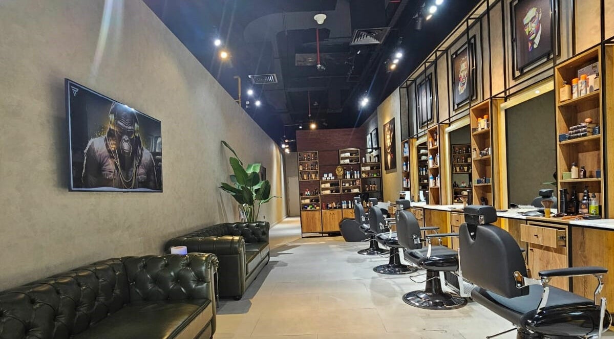 Interior of Elejon Barbershop, Dubai, AE with sleek chairs, art, and modern decor under cozy lighting.
