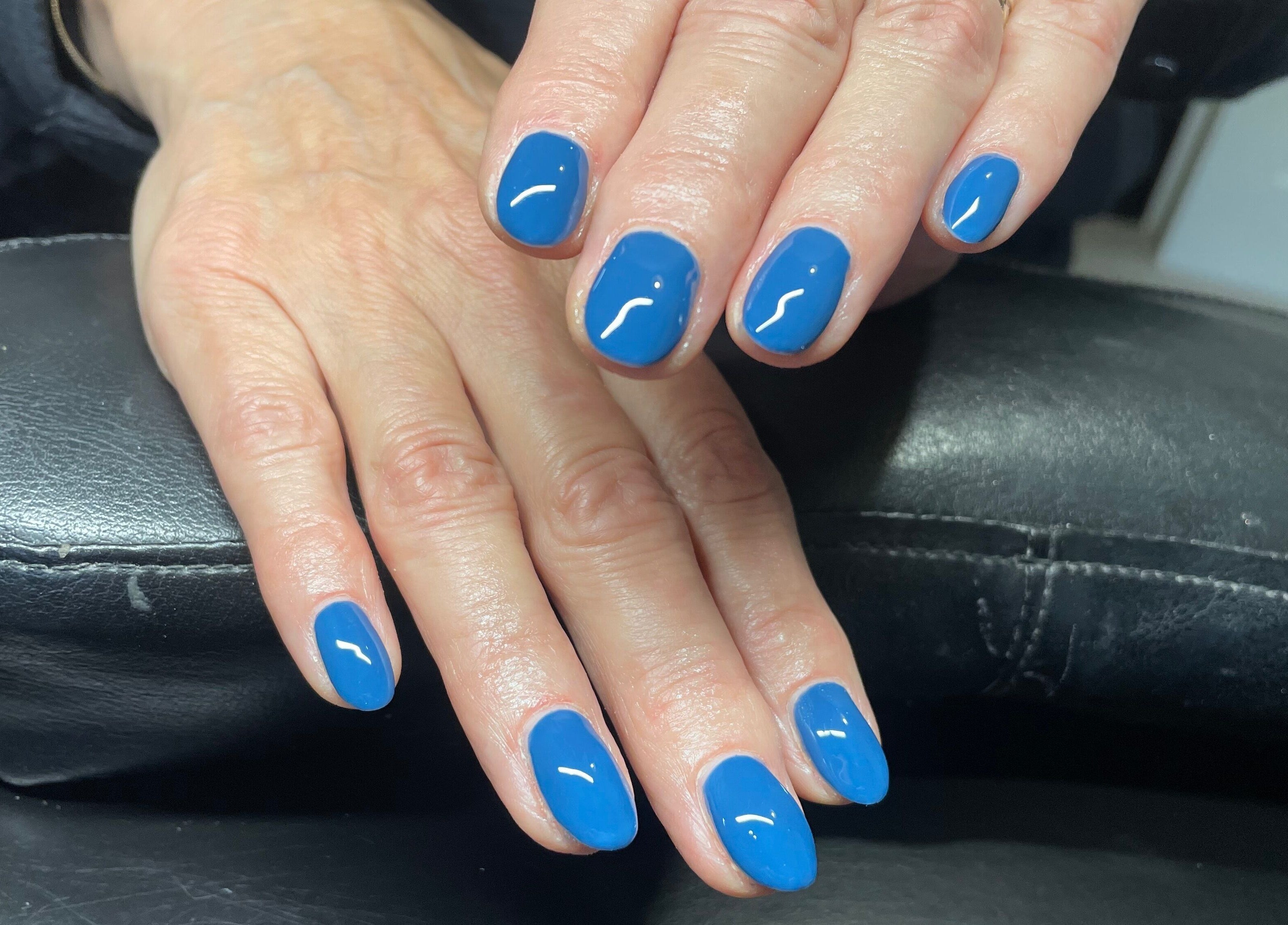 Vibrant blue manicure at House of Wax, Wrexham, Wales, GB showcasing expertly polished nails.