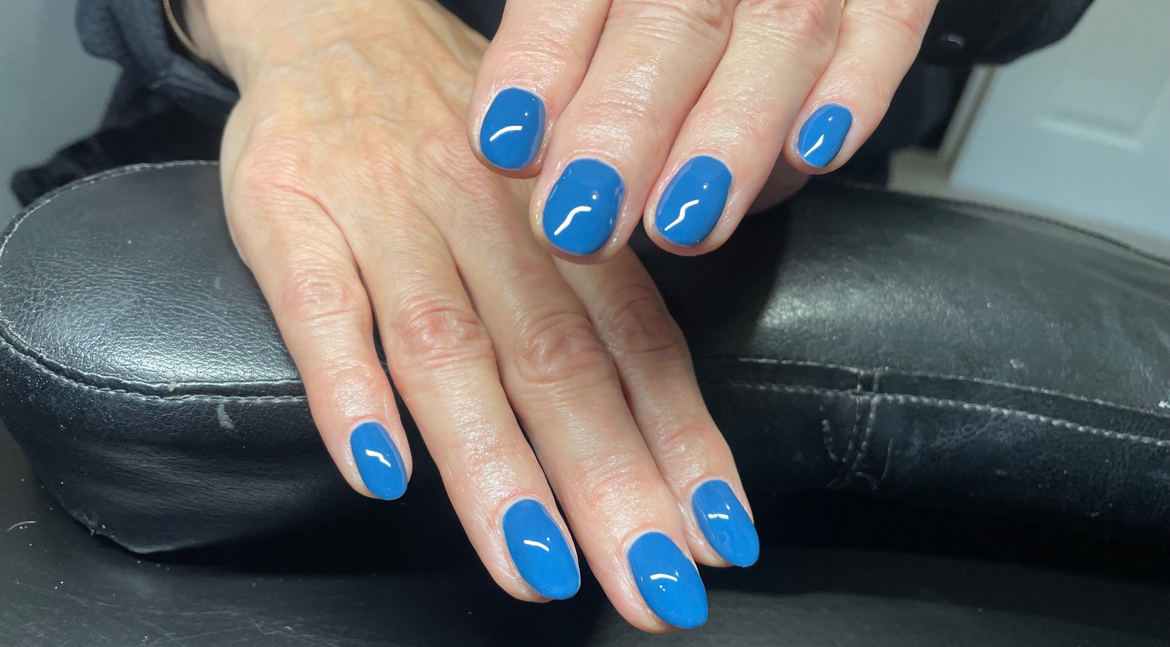 Vibrant blue manicure at House of Wax, Wrexham, Wales, GB showcasing expertly polished nails.