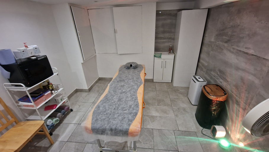 Cozy treatment room at La Baba, London, England, GB with a massage bed and elegant decor.