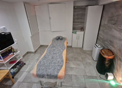 Cozy treatment room at La Baba, London, England, GB with a massage bed and elegant decor.