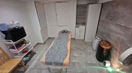 Cozy treatment room at La Baba, London, England, GB with a massage bed and elegant decor.