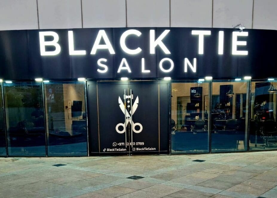 Elegant storefront of Black Tie Salon - Gent’s Spa and Barbershop in Dubai, Dubai, AE at dusk.