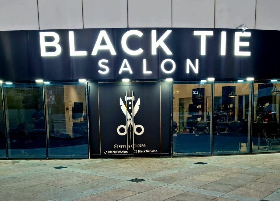 Elegant storefront of Black Tie Salon - Gent’s Spa and Barbershop in Dubai, Dubai, AE at dusk.