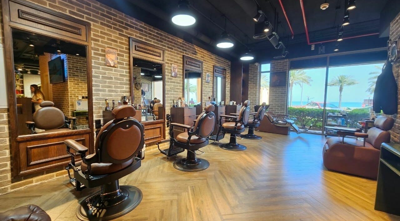 Stylish interior of Peaky Blinders | The Palm barbershop in Dubai, AE, with beachfront view.