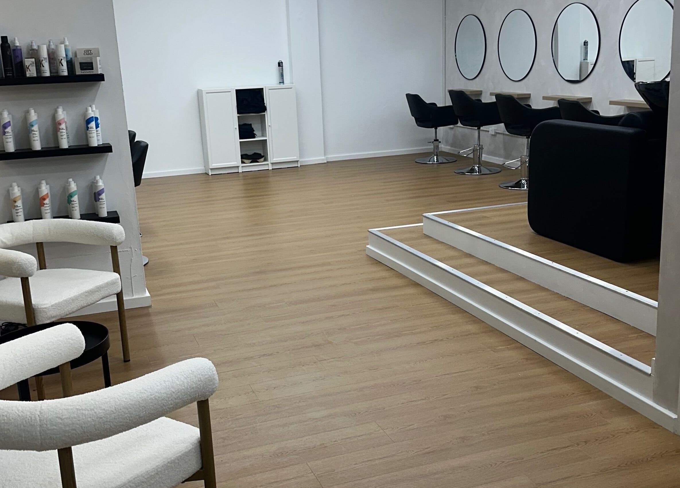 Modern salon interior at Allure Artistry, Penrith, New South Wales, AU, featuring sleek chairs and product displays.