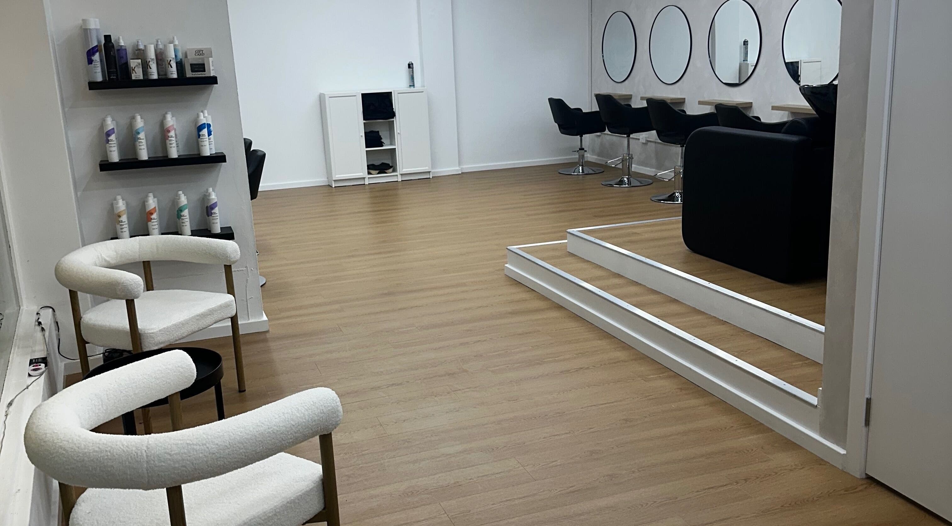 Modern salon interior at Allure Artistry, Penrith, New South Wales, AU, featuring sleek chairs and product displays.