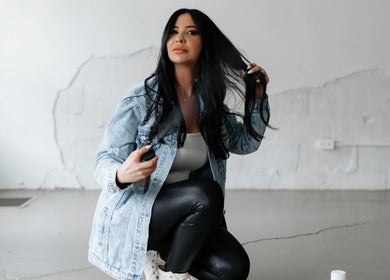 Woman styling hair at Hairby Maha, Windsor, Ontario, CA, showcasing modern hair techniques.