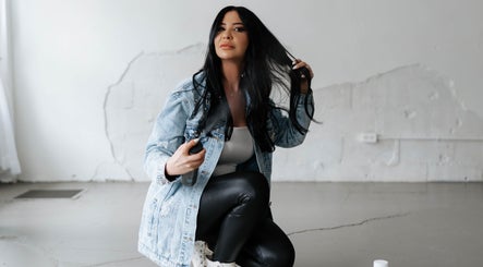 Woman styling hair at Hairby Maha, Windsor, Ontario, CA, showcasing modern hair techniques.