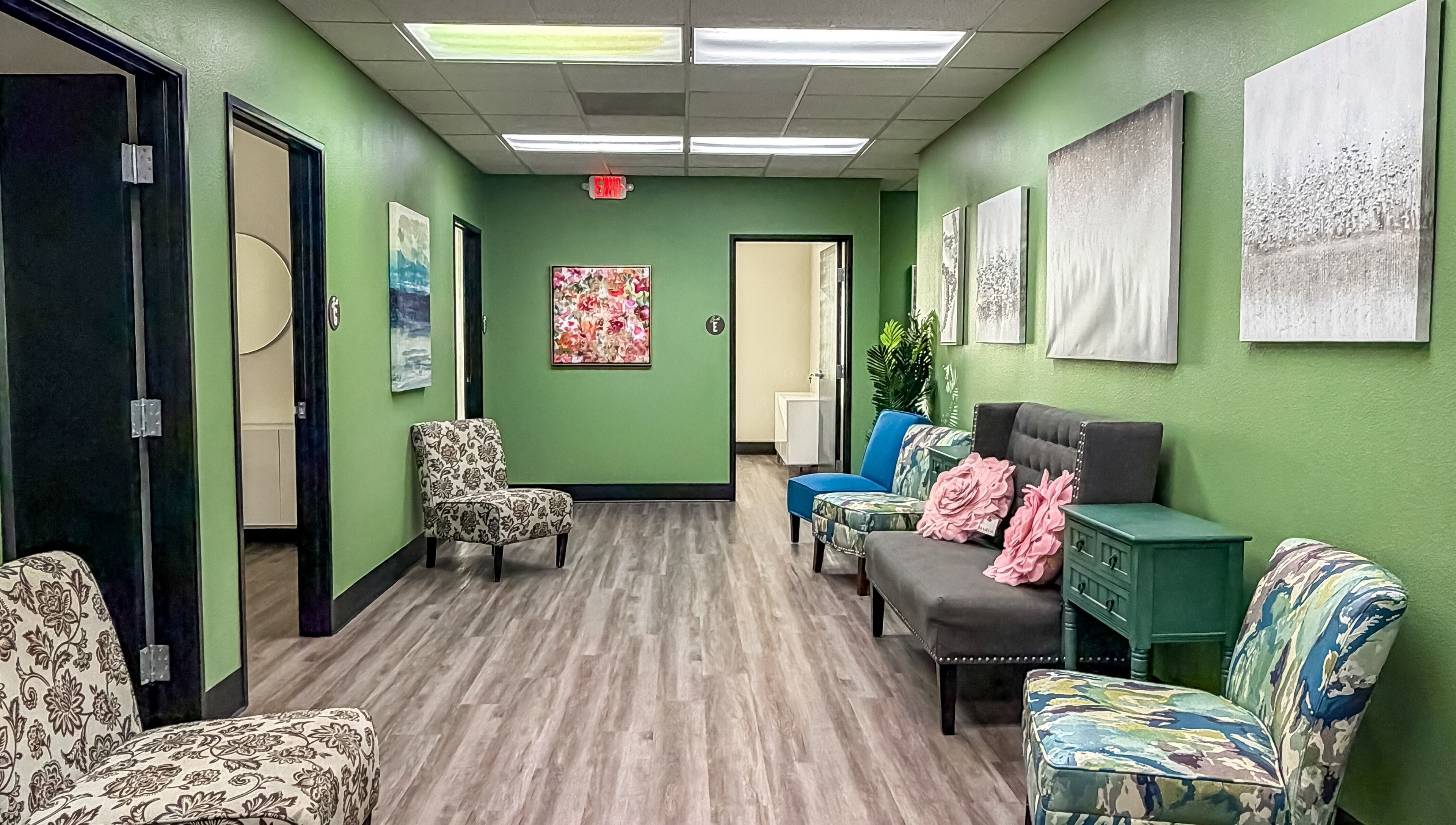 Inviting hallway with patterned chairs and art at Spa Haven Suites, Henderson, Nevada, US.