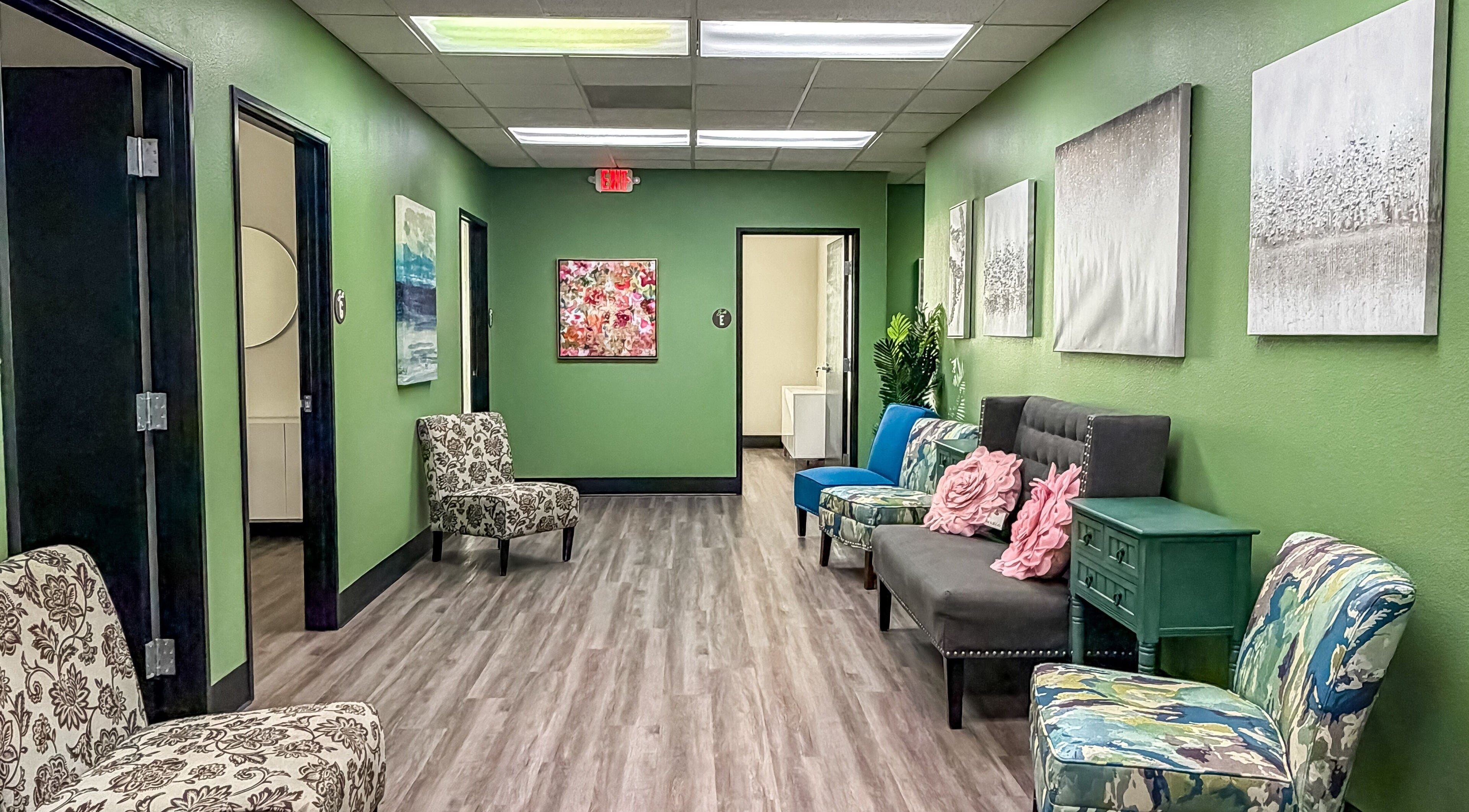 Inviting hallway with patterned chairs and art at Spa Haven Suites, Henderson, Nevada, US.