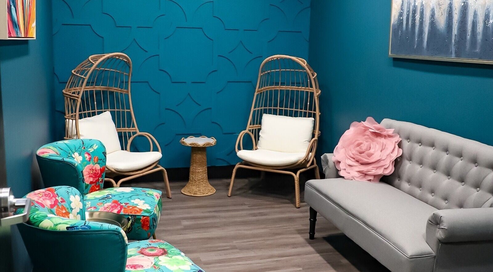 Serene lounge at Spa Haven Suites, Henderson, Nevada, US, featuring cozy wicker chairs and vibrant floral decor.