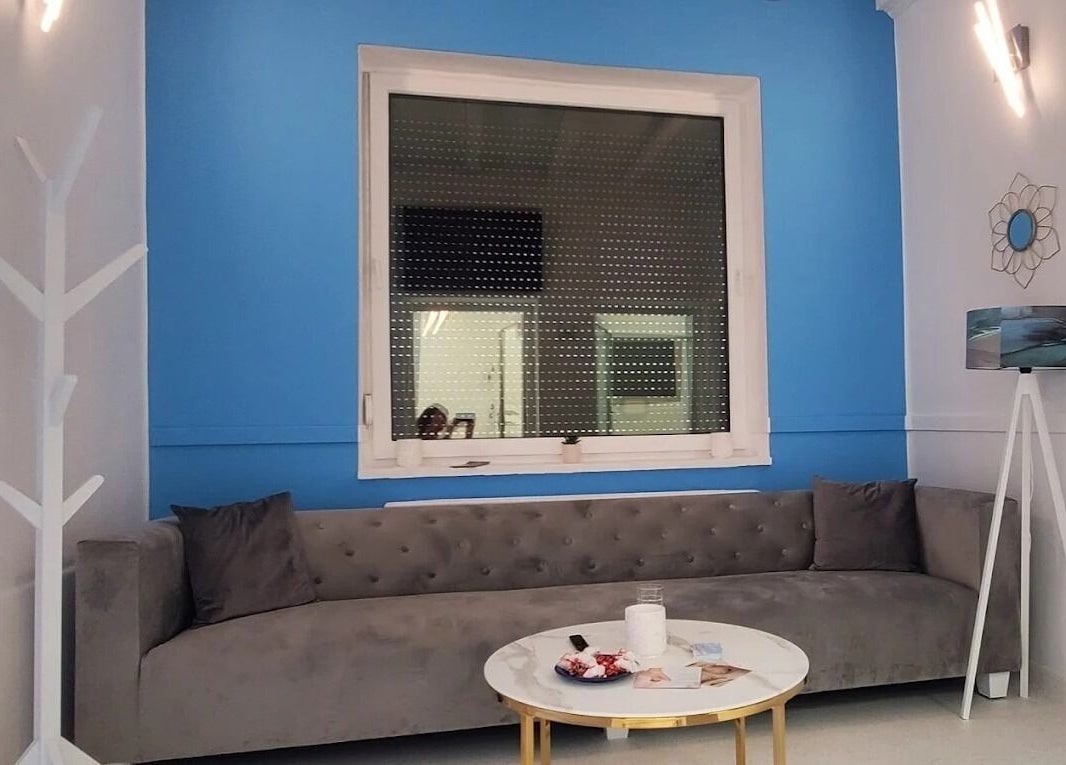 Salon modern la Dermatique, Timișoara, Județul Timiș, RO cu canapea gri și pereți albaștri.