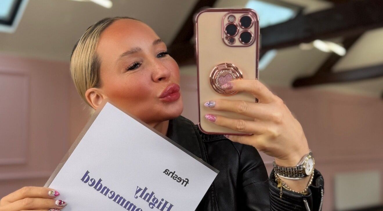 Customer snapping a selfie at House of Bellissima, Birmingham, England, GB with a phone and award certificate.