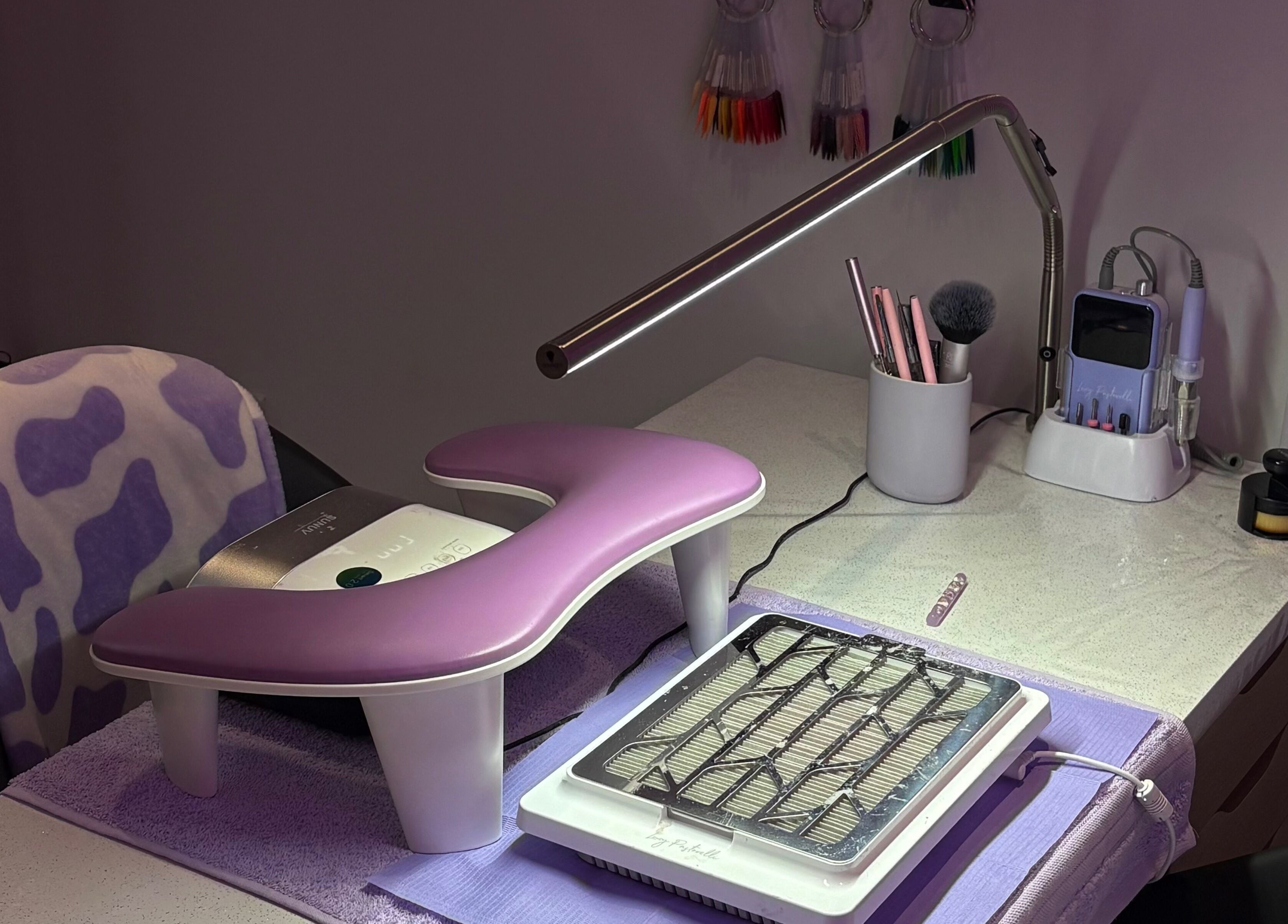 Nail station at Nails By Molly, Maxey, England, GB, featuring a purple rest, tools, and lighting.