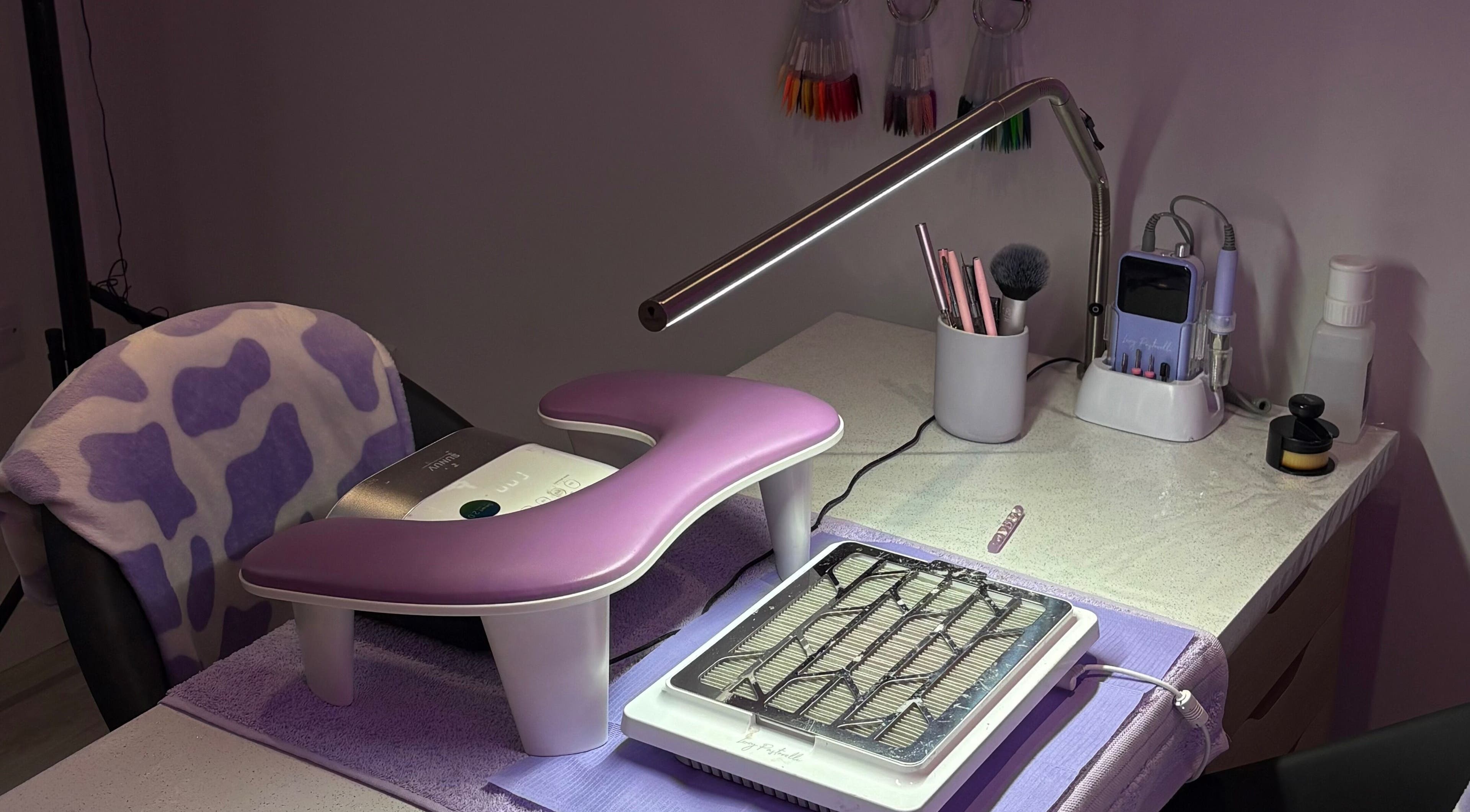Nail station at Nails By Molly, Maxey, England, GB, featuring a purple rest, tools, and lighting.