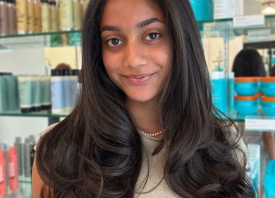 Smiling woman showcasing silky hair at Premier Hair Centre, Toronto, Ontario, CA.
