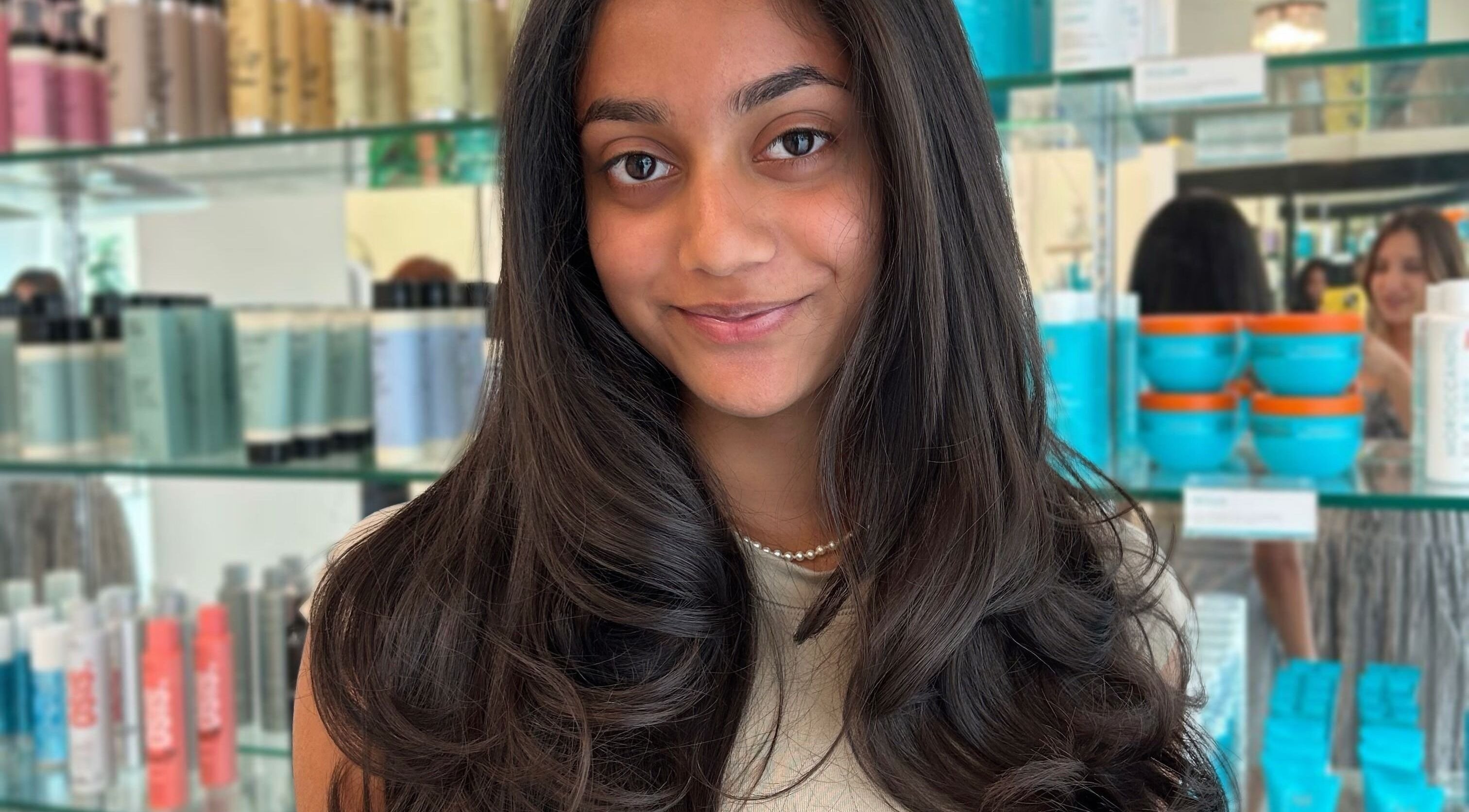 Smiling woman showcasing silky hair at Premier Hair Centre, Toronto, Ontario, CA.