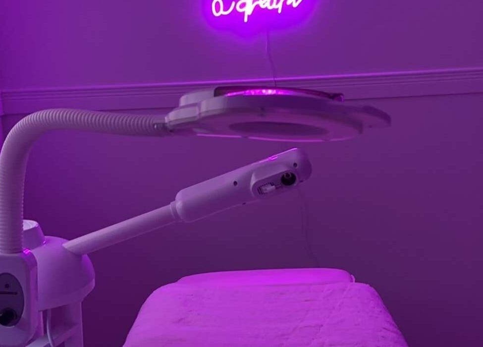 Modern treatment room at Glambyle, Ottawa, Ontario, CA, with neon lighting and skincare equipment.