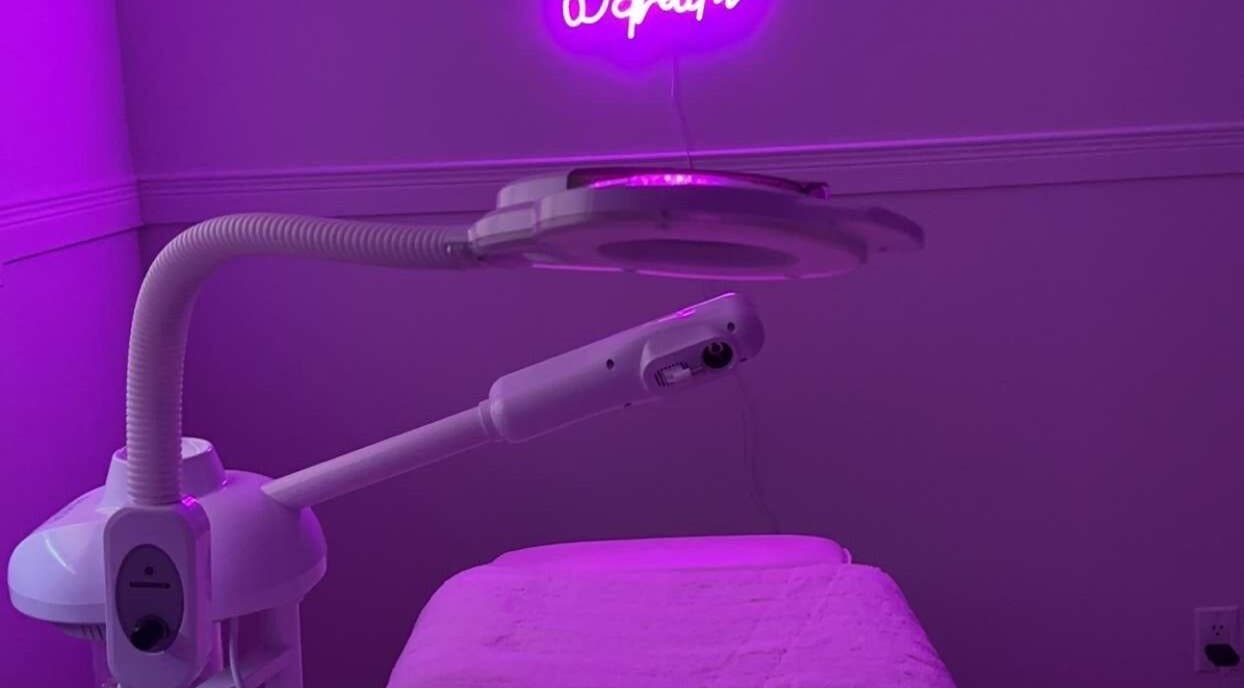 Modern treatment room at Glambyle, Ottawa, Ontario, CA, with neon lighting and skincare equipment.
