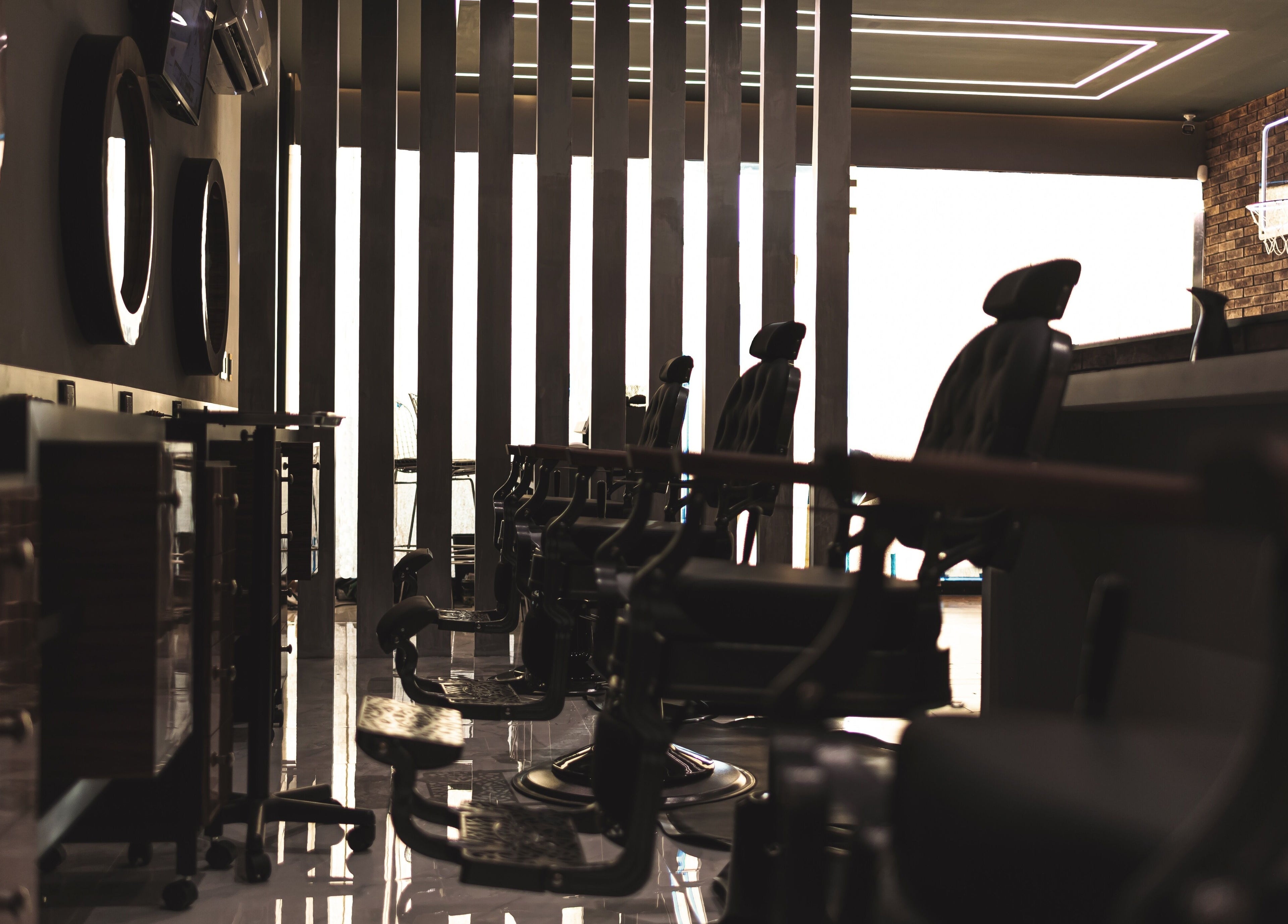 Interior moderno de Barber Sports & Spa Los Mochis en Sinaloa, MX, destacando sillas de peluquería elegantes.