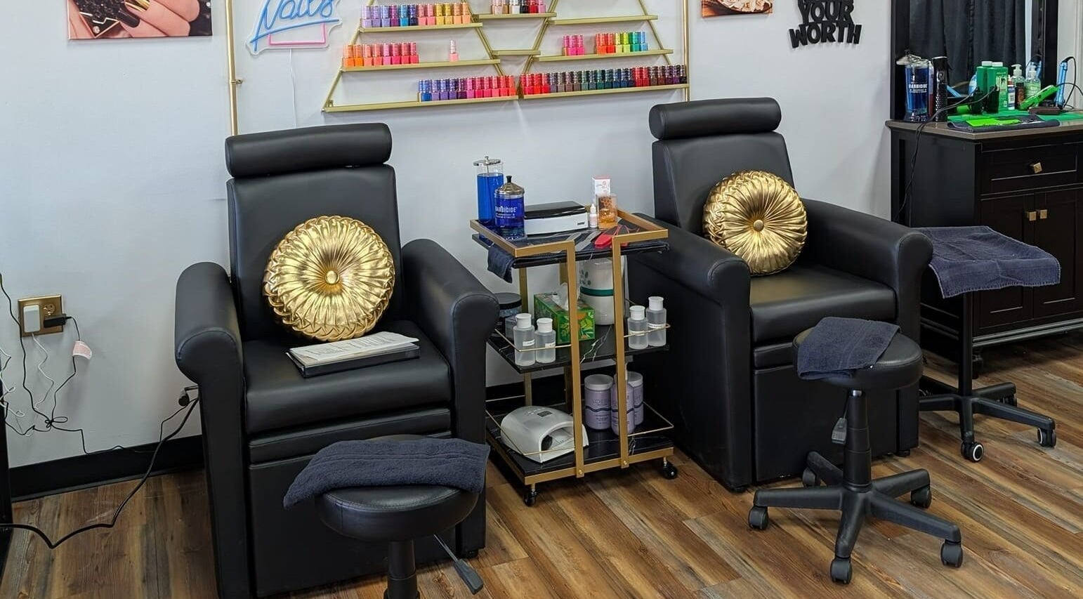 Elegant nail lounge at Legacy Salon, Warrensburg, Missouri, US with black chairs and gold accents.