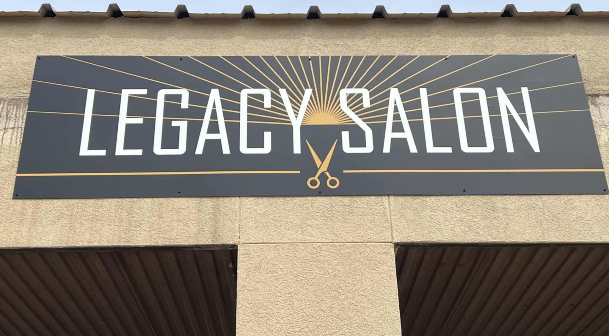 Legacy Salon entrance sign in Warrensburg, Missouri, US with elegant scissors logo.