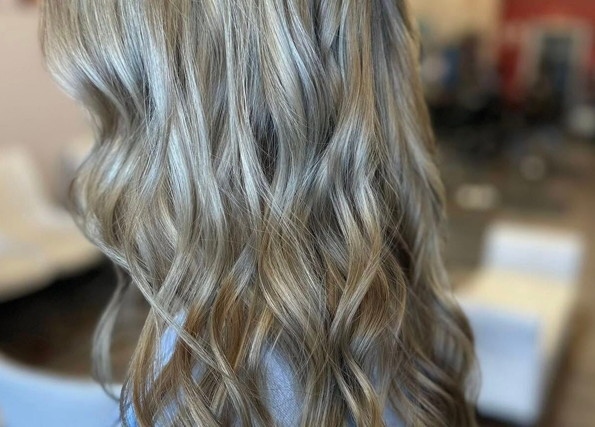 Wavy blonde hairstyle at Legacy Salon in Warrensburg, Missouri, US, showcasing elegant styling.