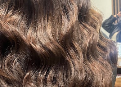 Shiny, wavy brown hair at KG Hair salon, Newport, Wales, GB, reflecting expert styling.